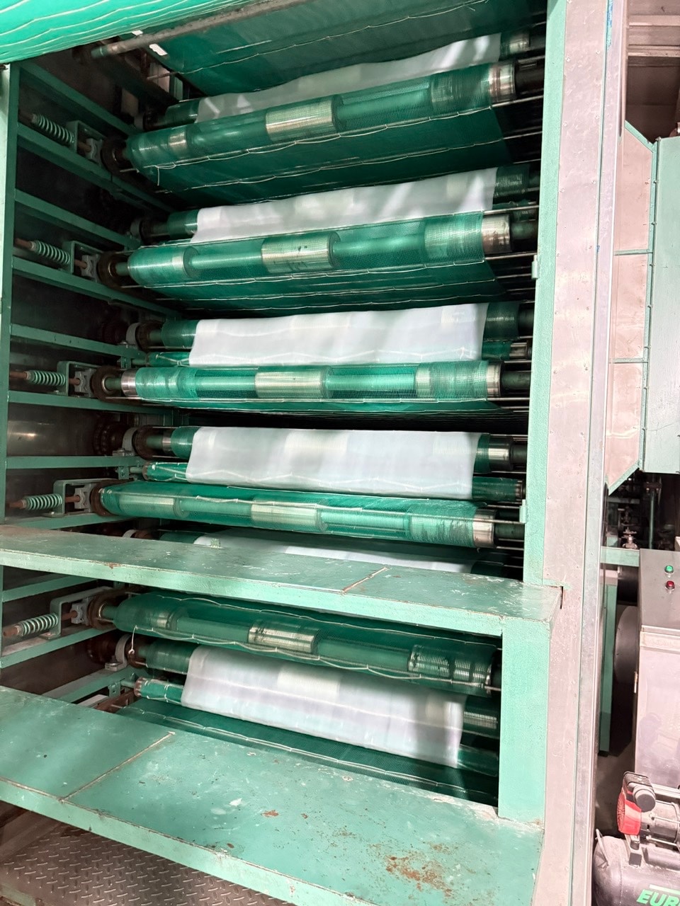 Cụm con lăn inox và băng tải trong khu vực sản xuất.