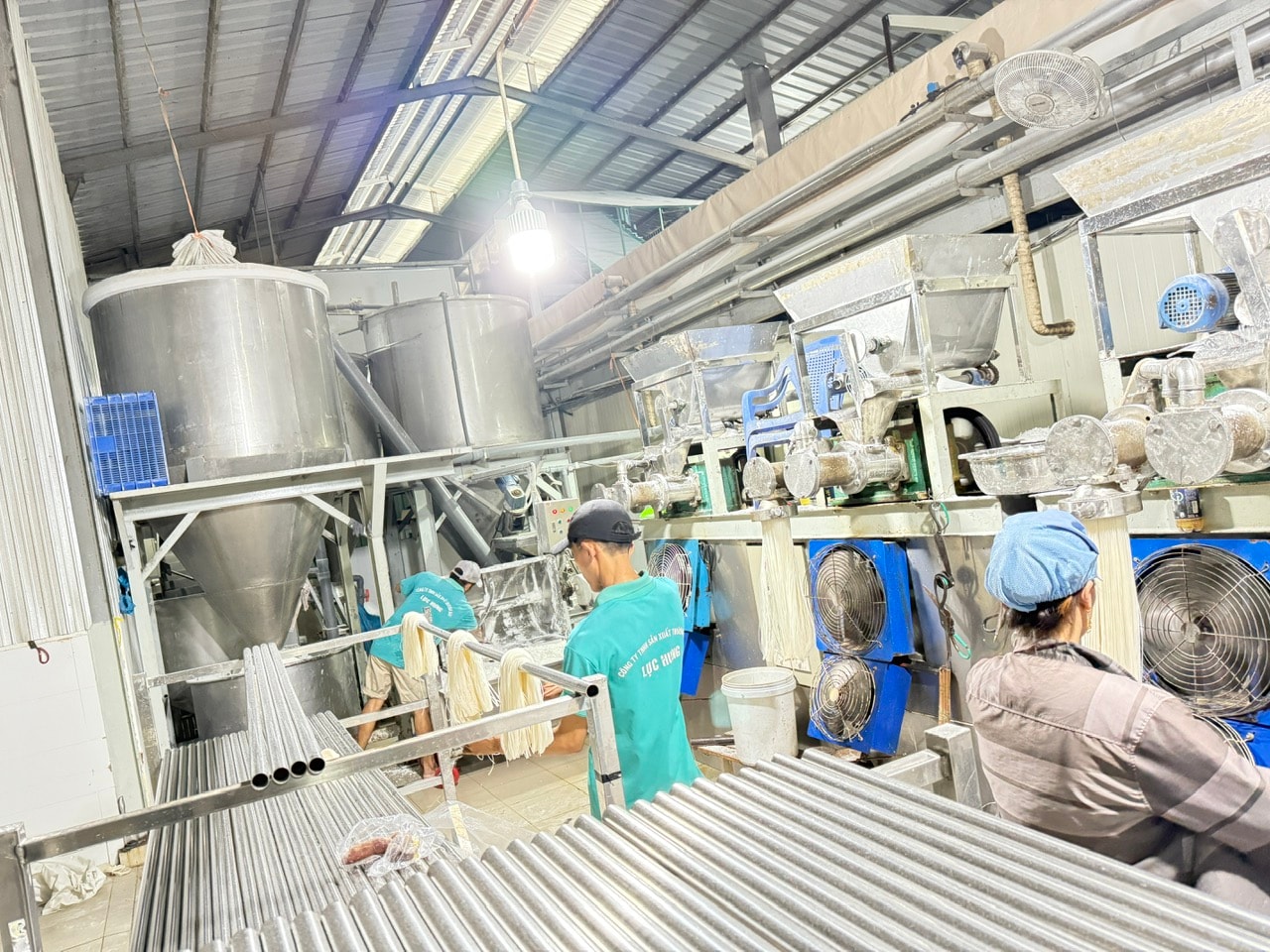 Các sợi sản phẩm được dẫn xuống từ cụm thiết bị.
